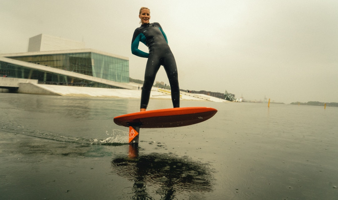 OPERAFANTOMET: Oda Johanne Stokstad Brødholt følte for å gi oslogryta en sjanse med foilbrettet. Foto: Christian Nerdrum jente som surfer foran operahuset i Oslo