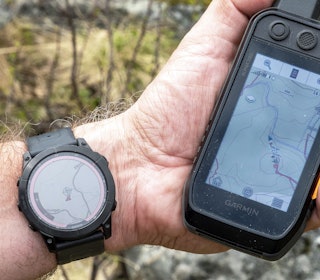 Godt par: Parkobla med en Alpha-peiler får du jakthundens posisjon rett inn på klokka, slik at du kan ha hendene fri under jakta. Jeg vrir gjerne urskiva på innsida av håndleddet, slik at jeg kan holde børsa klar når rådyrlosen nærmer seg. Hånd med Garmin Fenix 7X Sapphire Solar og Garmin Alpha 200 hundepeiler