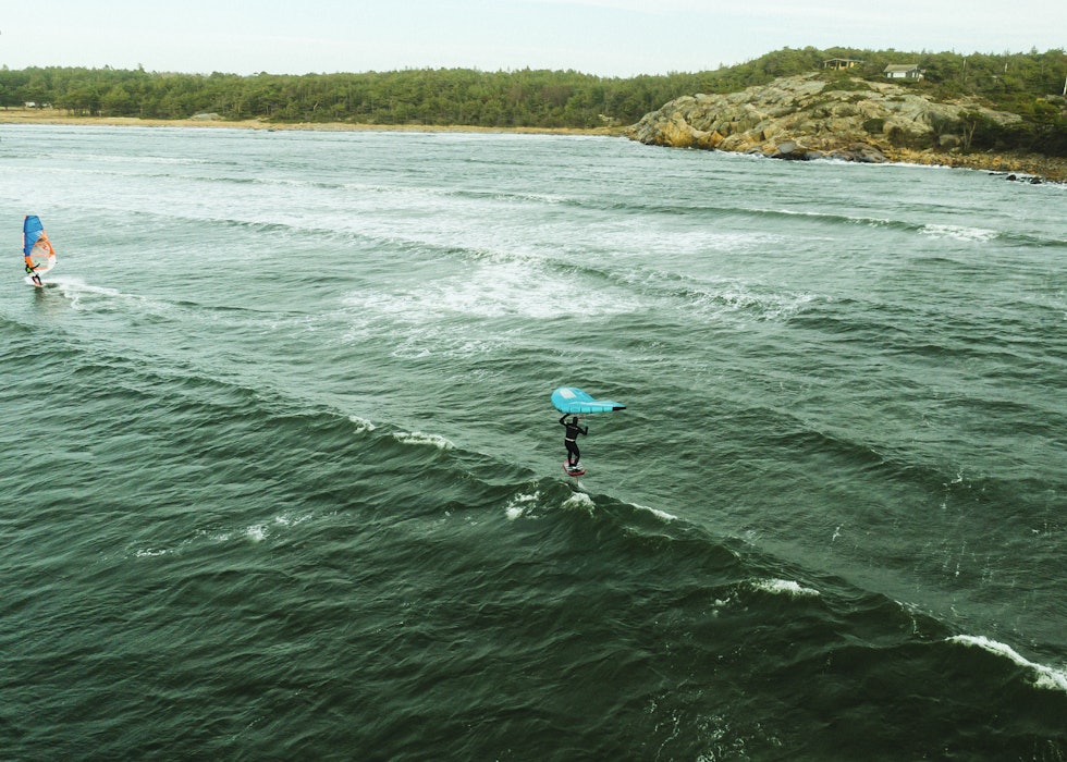 SURFER: Benjamin Jensen finner seg en bølge på Ørekroken, flagger ut vingen og surfer flere hundre meter. Foto: Christian Nerdrum