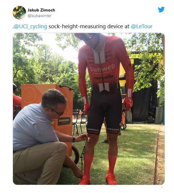 PASSER PÅ: De internasjonale dommerne utfører en sokkelengdesjekk under Tour de France 2021. Skjermdump, twitter.