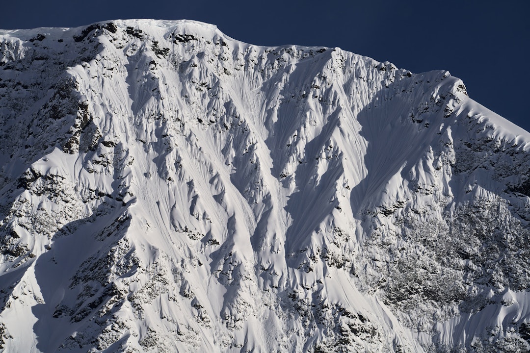 EKSPONERT: Krister sender ned snø idet han gjør den eksponerte traversen øverst i Jiehkkevárris sørvegg. Foto: Anders Vestergaard