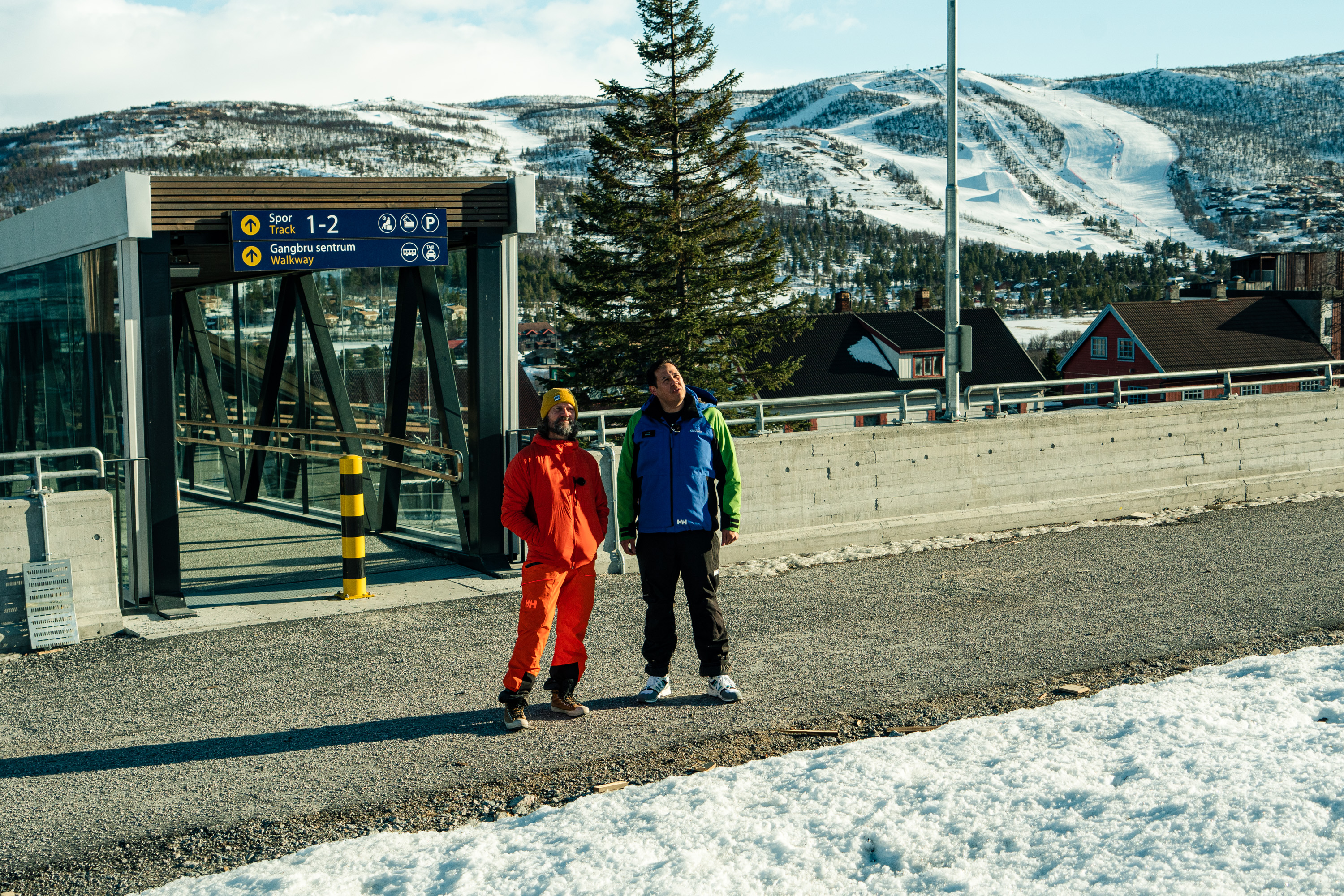 NY TAUBANE: Bård Gundersen og Kevin Eikrehagen står ved togstasjonen på Geilo og ser opp mot området der det på sikt skal settes opp en taubane på Geilo. Foto: Christian Nerdrum