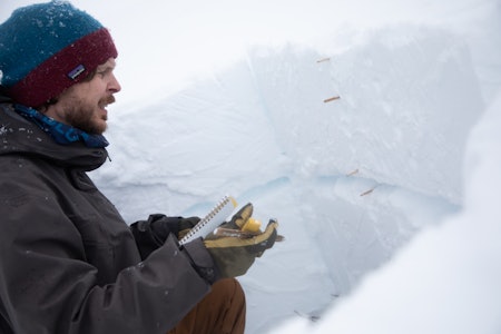 GRUNNLAG FOR TRØBBEL: Skredobservatør Pål Røsrud studerer det svake laget i snøen som kan bidra til å øke snøskredfaren i Trollheimen. Foto: Tore Meirik