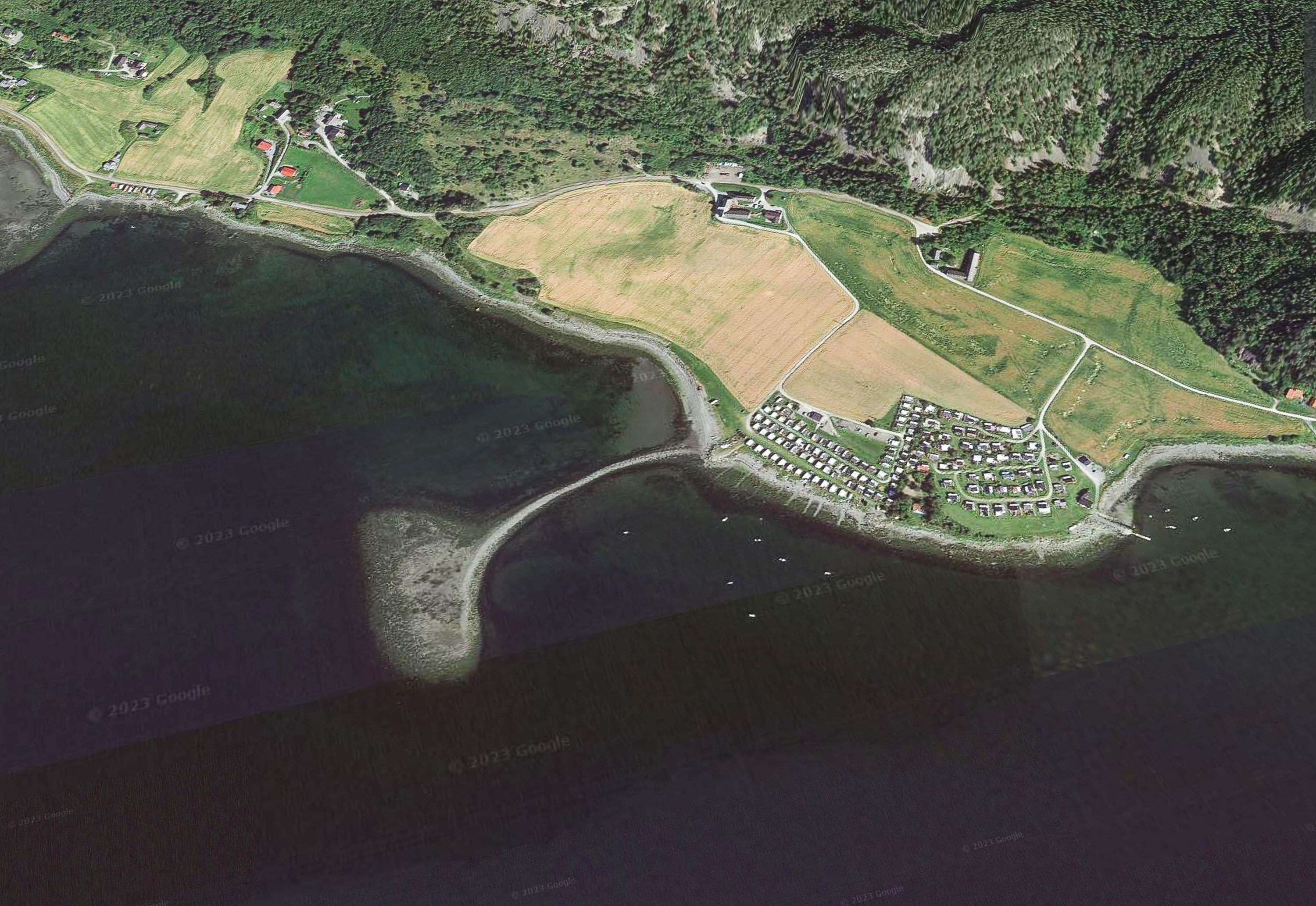 VINGE: En lang molo strekker seg øst/vest ut fra land og ut til en liten halvøy.