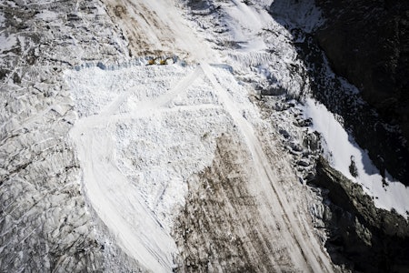 OMSTRIDT: Det vakte sterke reaksjoner da det ble brukt gravemaskin på en krympende isbre i Sveits for å lage skiløype. Nå viser det seg at arrangøren har gravd utenfor det tillatte området. Foto: Sébastien Anex/ 20minutes.ch