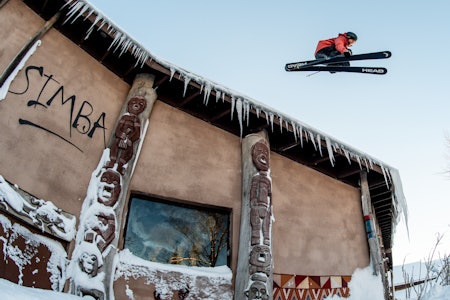 EKSOTISKE GREIER: Mye er uvanlig med dette bildet. Løven Simba følger med mens Anders Backe kjører ski ned fra løvens tak. Foto: Johnsen