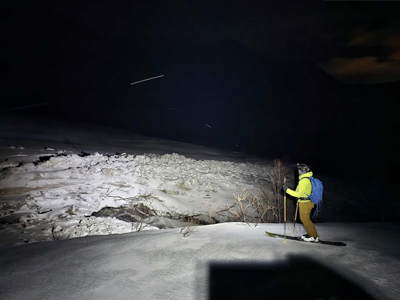 SKRED I SLAKT TERRENG: Sørpeskred trenger ikke rare helningen for å bli skumle. Dette sørpeskredet skjedde på Kvaløya i Troms sist helg. Foto: OlaMET/ Regobs skiløper som ser på snøskred