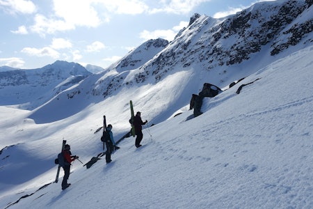 tre personer med ski på sekken på tur i vinterfjellet