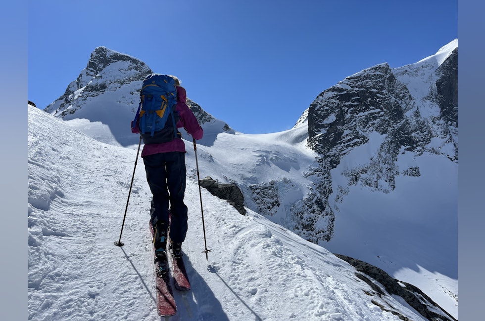 jente på skitur med fjell i bakgrunnen