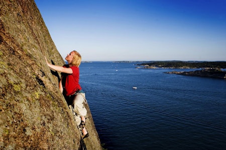 SNART SOMMER: Mirian Stavik Aksnes klatrer på Odderøya. Foto: Kristin Ellefsen dame som klatrer med hav i bakgrunnen