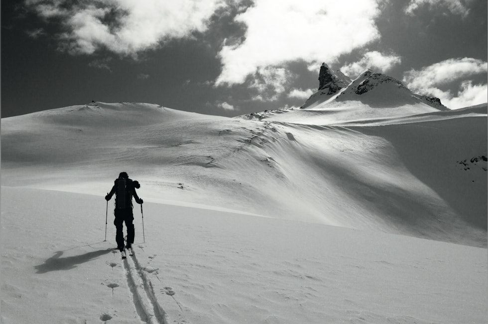 skiløper på vei mot spisst fjell
