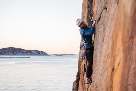 FØRST: Lukas Lindner på førstebestigningEN av Gullgaffel (7-) på Rosenrotveggen ved Kamberget. Foto: Trond Hauklien Klatrer med fjord i bakgrunnen