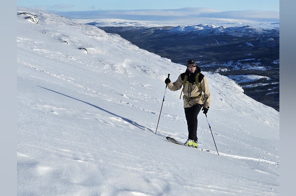 mann som går oppoverbakke på ski