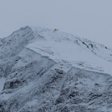 helikopter over snøkledt fjell