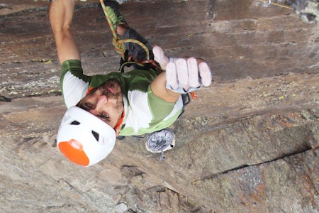 Spanske Alex Corpa på toppen av den selvsikrede ruten Variante de Extraplomos, 7c, på 3200 meters høyde i Sierra Nevada. Foto: Trond Ola Tilseth Mann med hjelm sett ovenfra på toppen av klatrerute med stort stup under beina, Han ser inn i kamera