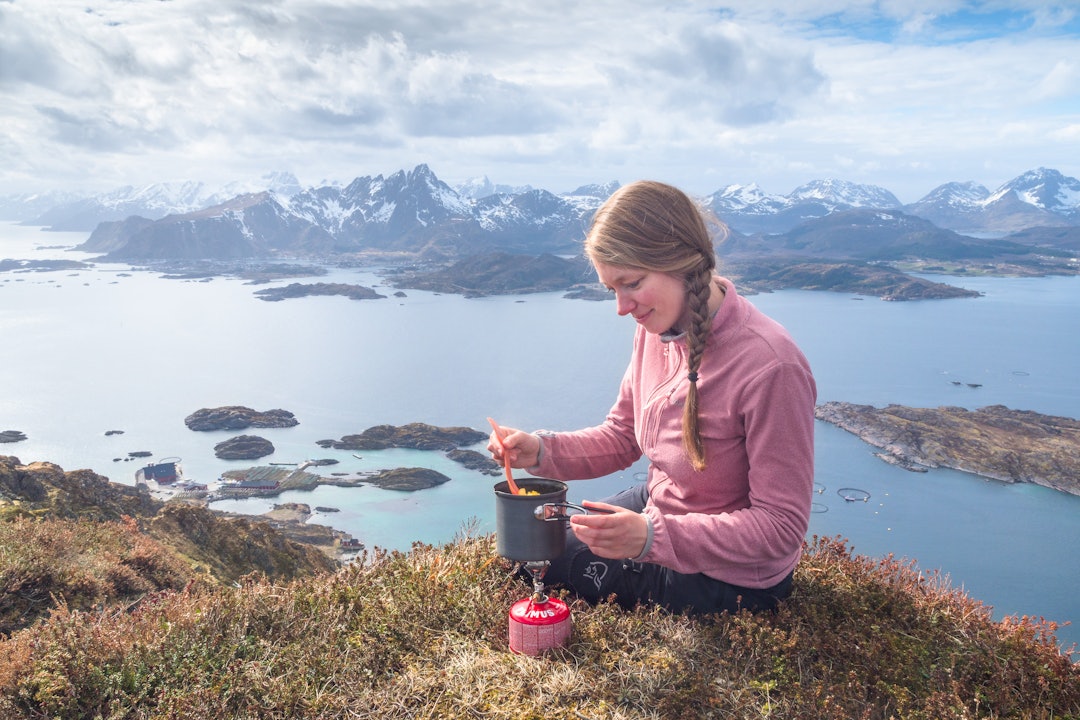 LUFTIG MATLAGING: Artikkelforfatteren på toppen av Middagstinden i Lofoten. Med Buksnesfjorden og Skottinden som bakteppe. Foto: Jon Olav Larsen middag på middagstinden