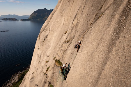 FØRSTEBESTIGNING: Vetle Sevild, Sofie Nordvik og Sigurd Norderval ble de første som klatret hele den 400 meter høye veggen Tromma på Kvaløya i Troms. Foto: Martin Andersen tre klatrere med havet i bakgrunnen