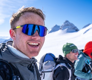 Nikolai Schirmer er blitt medeier i en app som legge til rette for at friluftsfolk finner turpartner. Foto: Vegard Aasen Nikolai Schirmer smiler i fjellet med blå himmel bak seg