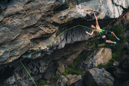 Leo Bøe på det harde startcruxet på Ilusionist (9a) i Flatanger. Foto: Adri Martínez sterk mann i bar overkropp osm klatrer i hule