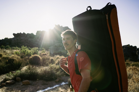 Thilo Schröter kan ikke huske å ha prestert bedre gjennom sine mange år som buldrer og klatrer. Foto: Anders Vest Mann med crashpad på ryggen, ettermiddagssol i bakgrunnen, sørafrikansk landskap med busker
