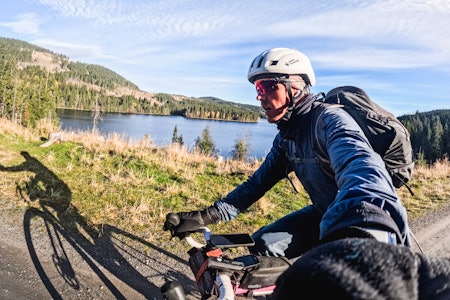 BIG DAY OUT: Andreas Fausko gjennomførte en av de kuleste turene man kan gjøre i Nordmarka. Foto: Andreas Fausko syklist på grusvei forbi vann
