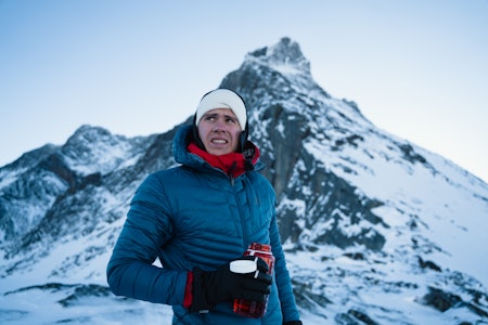 Bent Marius Rørstad. Foto: Anders Møller Vestgaard Mann i boblejakke og lue står med drikkeflaske foran fjelltopp med en del snø.