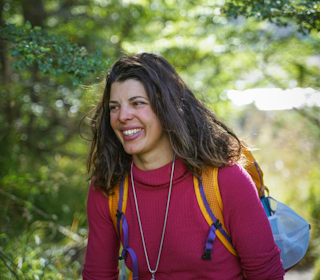 Sol Giadorou hjelper klatrere med psyken. Foto: Jack Porter Kvinne går i skogen med sekk på ryggen