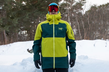 Vi har testet Arc'teryx' dyre toppmodell Sabre SV. Foto: Erlend Wassdahl Meirik mann i hage med fargerik jakka