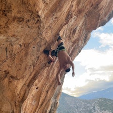 Arne Farestveit tar seg inn rett før cruxet på Nid De Fadas 8c+, som han jobber med i Hellas. Foto: Sindre Sollid Mann henger opp ned på bratt klatrerute