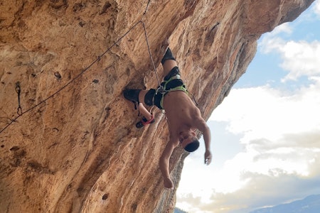 Arne Farestveit tar seg inn rett før cruxet på Nid De Fadas 8c+, som han jobber med i Hellas. Foto:  Sindre Sollid Mann henger opp ned på bratt klatrerute
