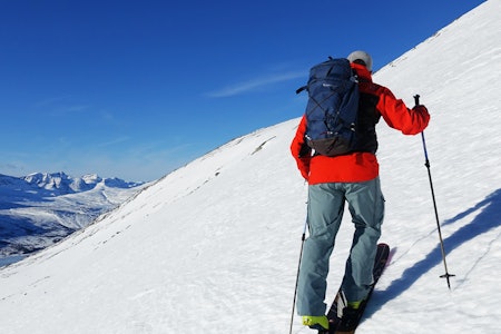 MANGE TESTER: Fri Flyt har testet en drøss sekker for topptur - sist ut er denne nyheten fra svenske Klättermusen. Foto: Maria Wassdahl Meirik mann med rød jakke på skitur i fjellet