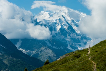 HØYFJELLSSTI: Når man sykler i Alpene får man satt ting i perspektiv. Fjellene er store, og vi syklistene blir veldig, veldig små. Sånn som i Chamonix, hvor Elle Cochrane sykler Le Tour med Europas høyeste fjell Mont Blanc (4810moh) bak seg. Foto: Mattias Fredriksson panaromautsikt over spisse snødekte fjell i alpene