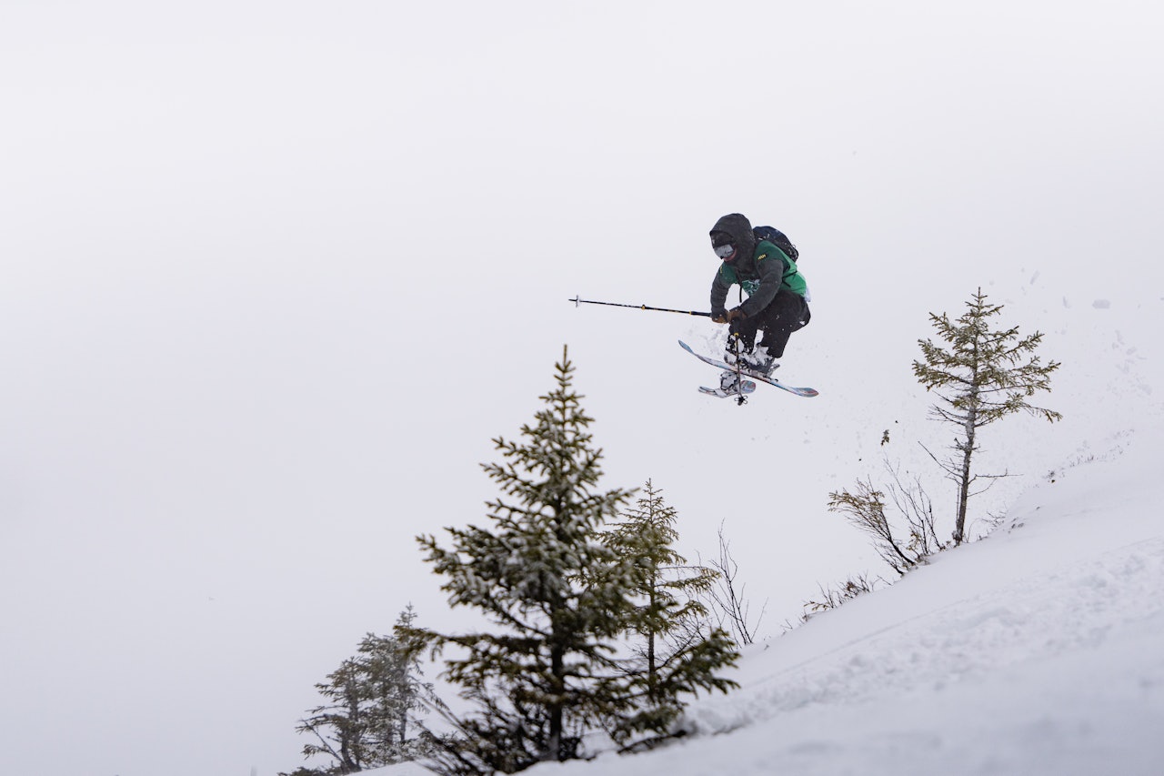 Foto: Kristian Aars/NTNUI (CC BY 4.0) En mann med ski henger i luften mellom to trær