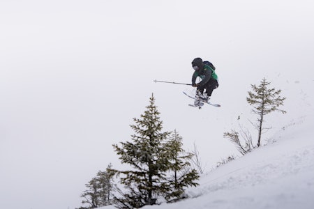 Foto: Kristian Aars/NTNUI (CC BY 4.0) En mann med ski henger i luften mellom to trær