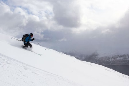 TRYGT ALTERNATIV: Giilavarri (KAST-grad 2)er blant de fineste toppturfjellene i Kåpfjord, og kan være et bra alternativ også når været bare er halvbra. Arkivfoto: Tore Meirik telemarkkjører med sjø i bakgrunnen