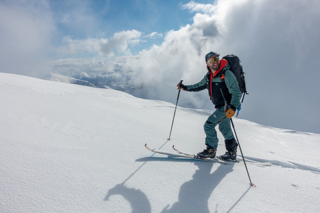 Finn Hovem i Safeback utstyrt med SBX-systemet. Foto: Safeback En mann går oppover på ski under blå himmel. Han har på blå jakke og bukse.