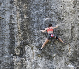 Ragnhild Eriksrud på Fish Eye (8c) i Oliana i Spania. Foto: Toni Mas Kvinne i kortbukser klatrer vertikal klippevegg på led.