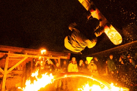Det gikk hett for seg under Sprinter City Railjam. Foto: Oskar Angelsen En mann tar en frontflip på snowboard over en brennende rail