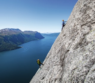 NORGES LENGSTE: Ikke mange steder i verden kan du klatre nesten 700 meter på borebolter i så nydelige omgivelser som dette. Her er Miroslav Pet´o først i tauet på Balansekoden (7-) i Eresfjord, sikret av legenden Iver Gjelstenli. Foto: Terje Aamodt to klatrere i fjellvegg med fjord i bakgrunnen