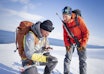 MER HENSYN: Rifle og signalpistol er like obligatorisk som skredsøker på Svalbard-tur. Foto: Kristin Folsland Olsen / Toppturfestivalen Svalbard To guider på svalbard diskuterer rutevalg den ene med rifle på ryggen