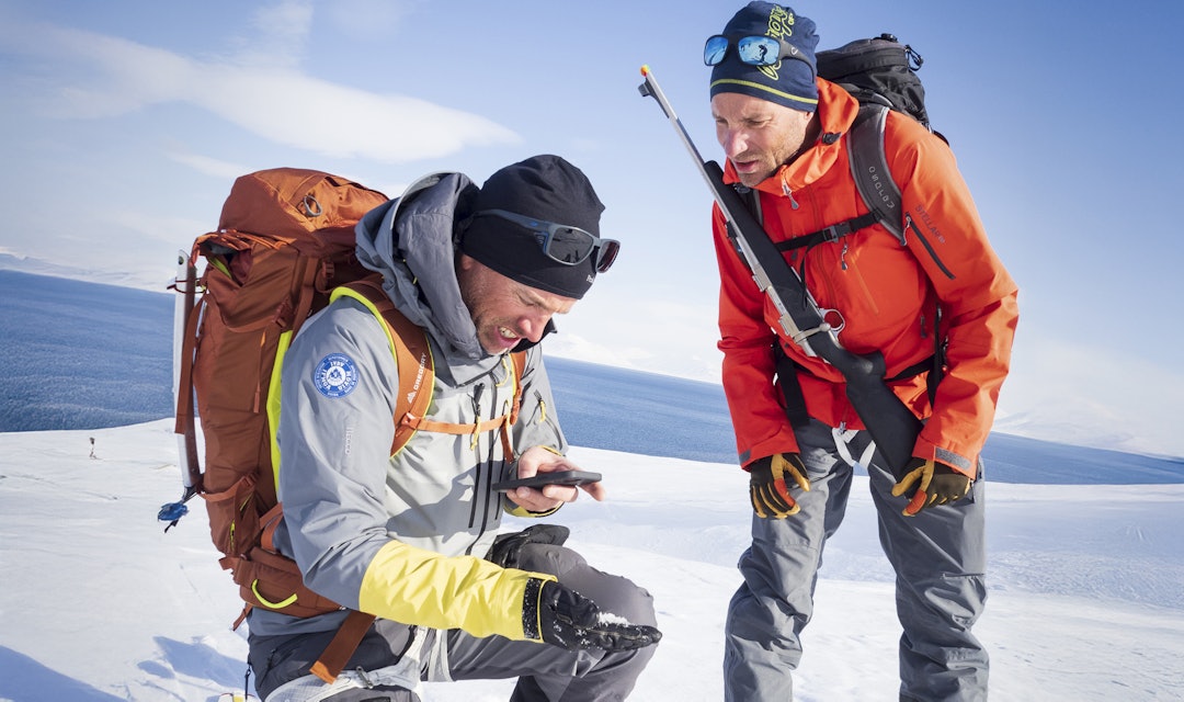 MER HENSYN: Rifle og signalpistol er like obligatorisk som skredsøker på Svalbard-tur. Foto: Kristin Folsland Olsen / Toppturfestivalen Svalbard To guider på svalbard diskuterer rutevalg den ene med rifle på ryggen