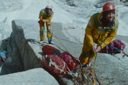 UNIK DOKUMENTASJON: Klipp fra den banebrytende klatringen i Pakistan, vises for første gang i kinofilmen Trango. To menn står i en klatrevegg med gule jakker og kikker oppover