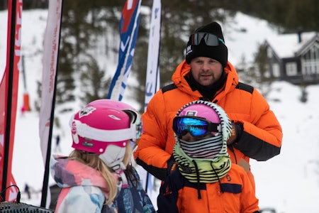 Hans Petter Bakke er imponert og overrasket over giverviljen når folk i Gudbrandsdalen samler inn penger for å redde skisenteret på Lemonsjøen. mann i oransje dunjakke foran kids