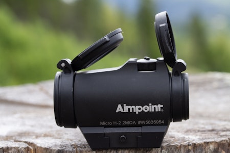 AIMPOINT MICRO H2: Et kompakt og robust rødpunktsikte utviklet spesielt for drivjakt. Det veier bare 130 gram med feste og leverer et skarpt, tydelig rødpunkt med 12 justerbare lysnivåer – perfekt for raske skudd i varierende lysforhold. Aimpoint Micro H2