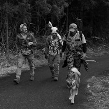 JAKTMILJØ: Shigeru Kato (til venstre) er ikke redd for å tilegne seg ny kunnskap. Nylig var han i Norge for å lære hvordan vi jakter, slik at han kan jakt mer effektivt hjemme i Japan. Foto: Privat Shigeru Kato med to jaktkompiser og en jakthund