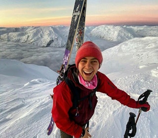 SKIGLEDE: Nicolai Drager studerer for øyeblikket skiveileder hos Nortind, og han deler lidenskapen for ski til følgerne sine på youtube og instagram. Foto: Sondre Eriksen Nicolai Drager på et fjell med rød jakke og et bredt smil