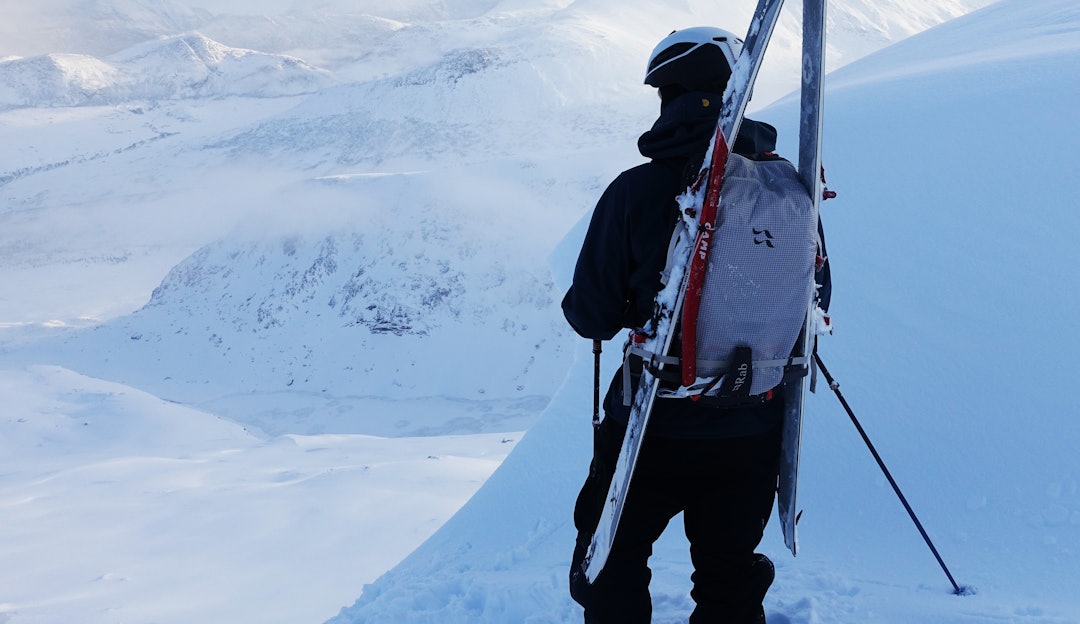 MANGE TESTER: Fri Flyt har testet en drøss sekker for topptur - sist ut er blant andre Rab Khroma 30. Foto: Erlend Wassdahl Meirik mann som ser på utsikten med ski på sekken
