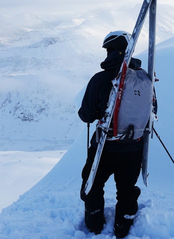 MANGE TESTER: Fri Flyt har testet en drøss sekker for topptur - sist ut er blant andre Rab Khroma 30. Foto: Erlend Wassdahl Meirik mann som ser på utsikten med ski på sekken