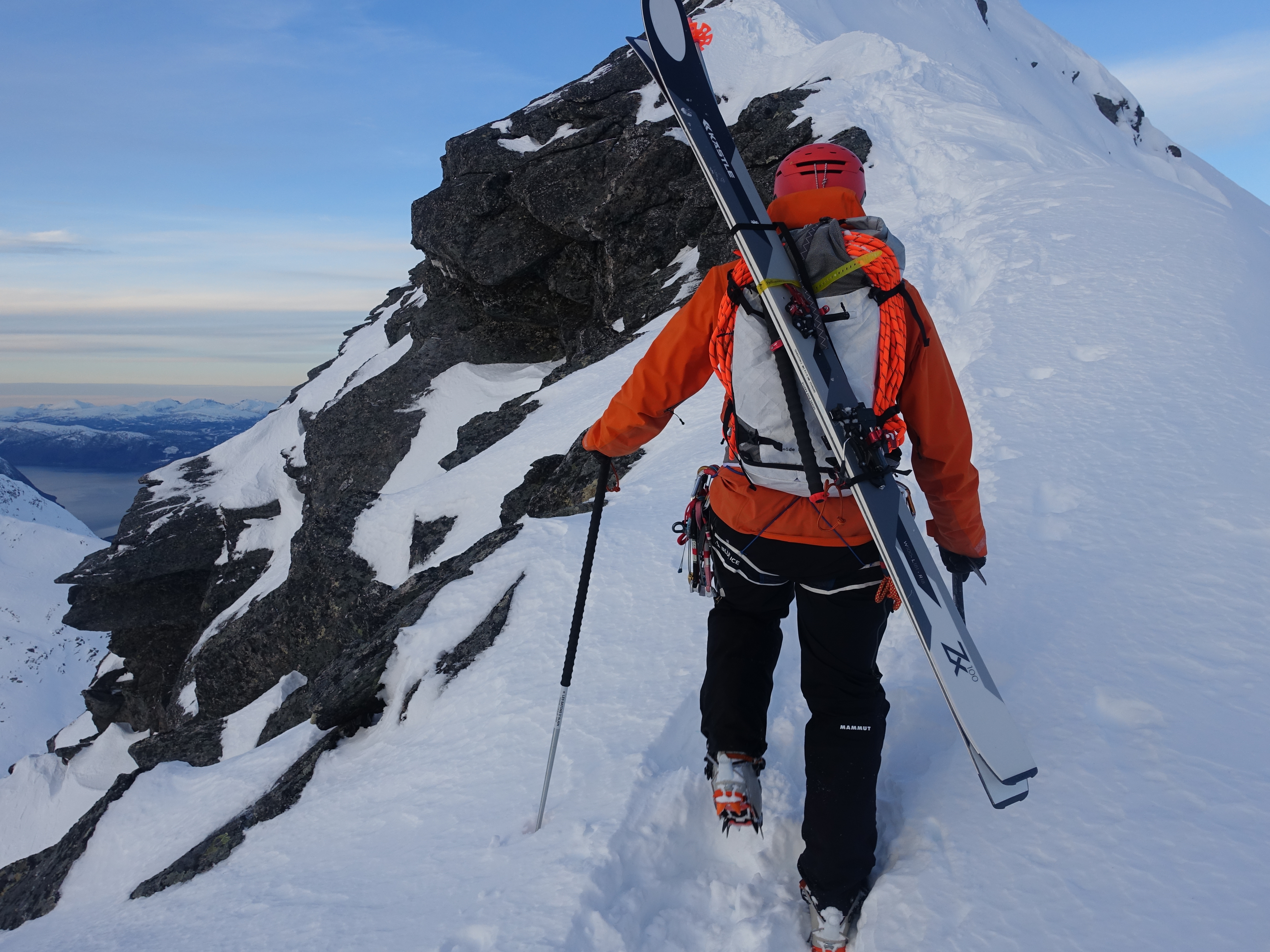 mann i fjellet med ski på sekken
