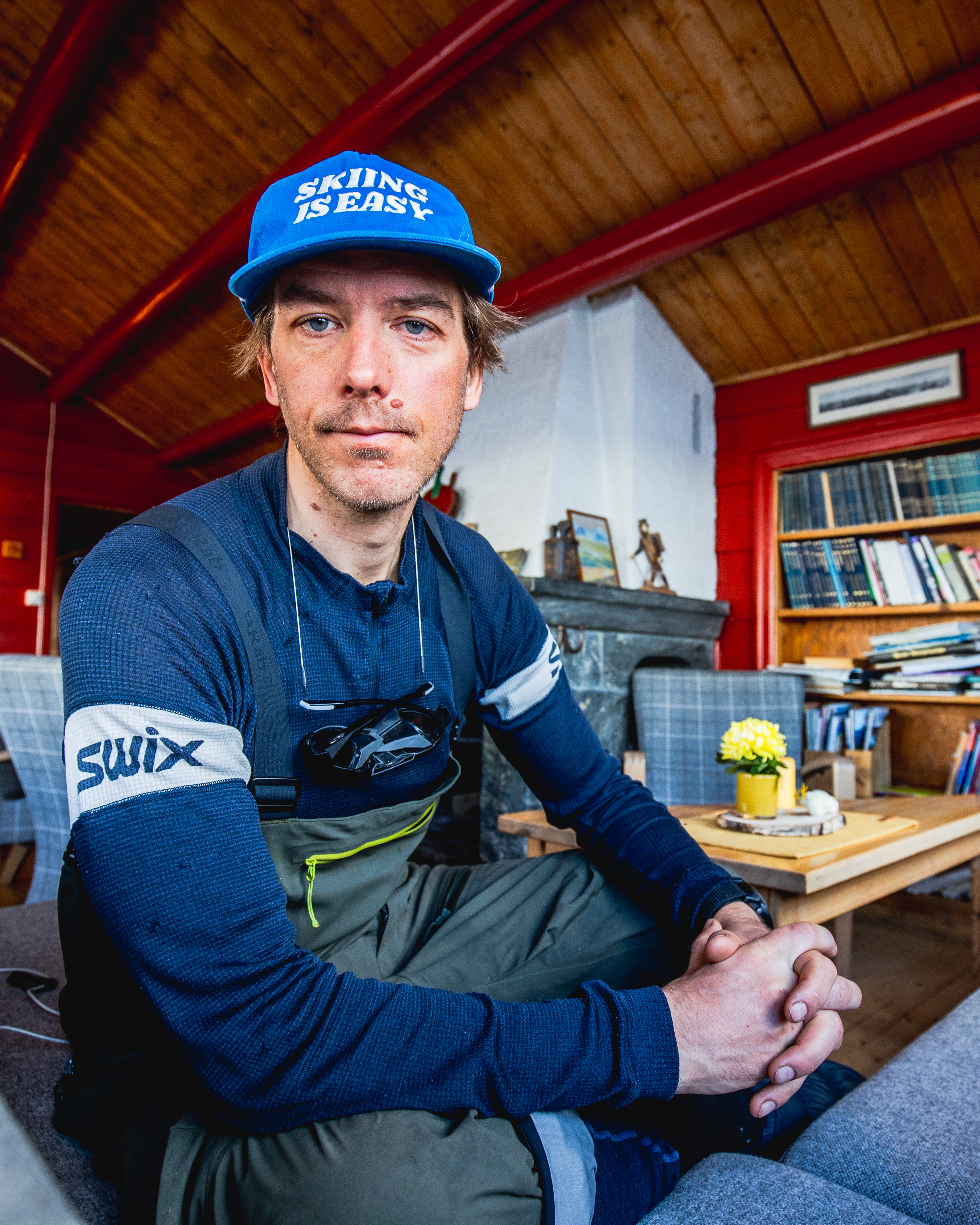 En oppgitt mann i turutstyr inne på en DNT-hytte.
